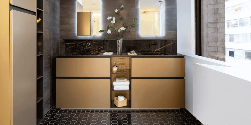Gold bathroom vanity cabinets with brown marble-look countertop